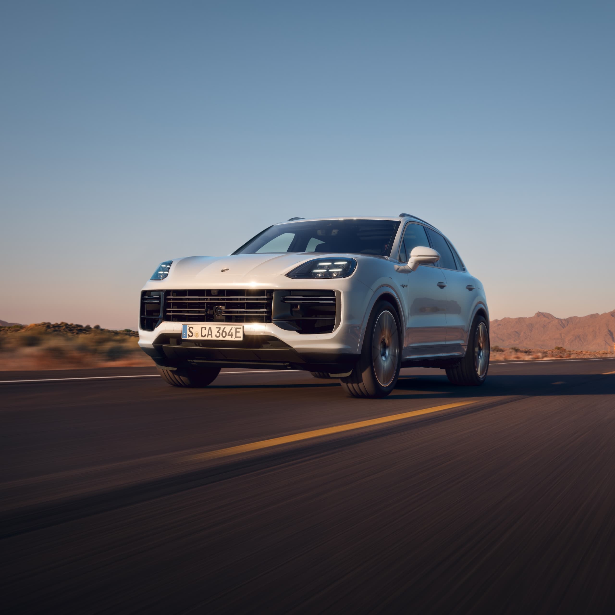 En Porsche Cayenne kjører på en åpen vei.